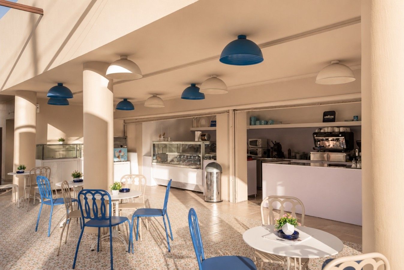 Seating area of Majestic Dodoni Cafe with blue lamps and pastel tiles