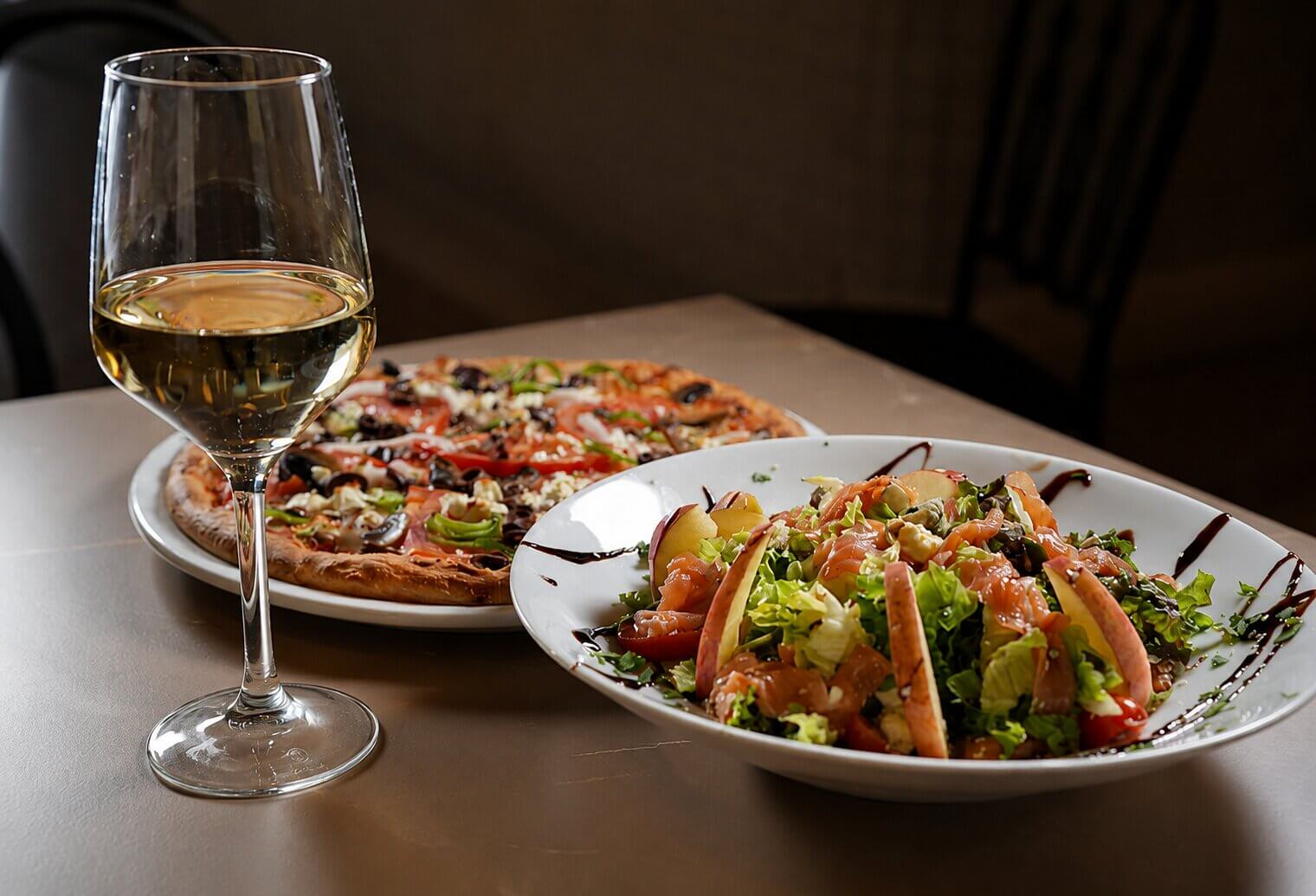 Pizza and salmon salad with white wine