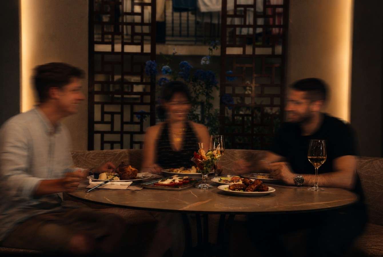 Friends dining together at a candlelit table at Majestic